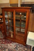 A MODERN CHERRYWOOD GLAZED DISPLAY CABINET WITH SLIDING DOORS AND THREE GLASS SHELVES H-155 W-104