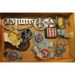 A COLLECTION OF VINTAGE CAR BADGES CONTAINED IN A GLAZED DISPLAY BOX