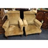 A PAIR OF ANTIQUE UPHOLSTERED ARMCHAIRS IN THE STYLE OF 'HOWARD & SONS'