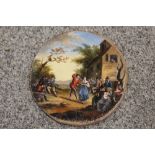 A SMALL 19TH CENTURY CIRCULAR OIL ON BOARD OF A VILLAGE SCENE WITH FIGURES BEFORE AN INN DIA-10CM