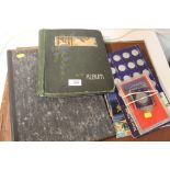 A VINTAGE POSTCARD ALBUM TOGETHER WITH THREE STAMP ALBUMS, COLLECTABLE TOKENS ETC.