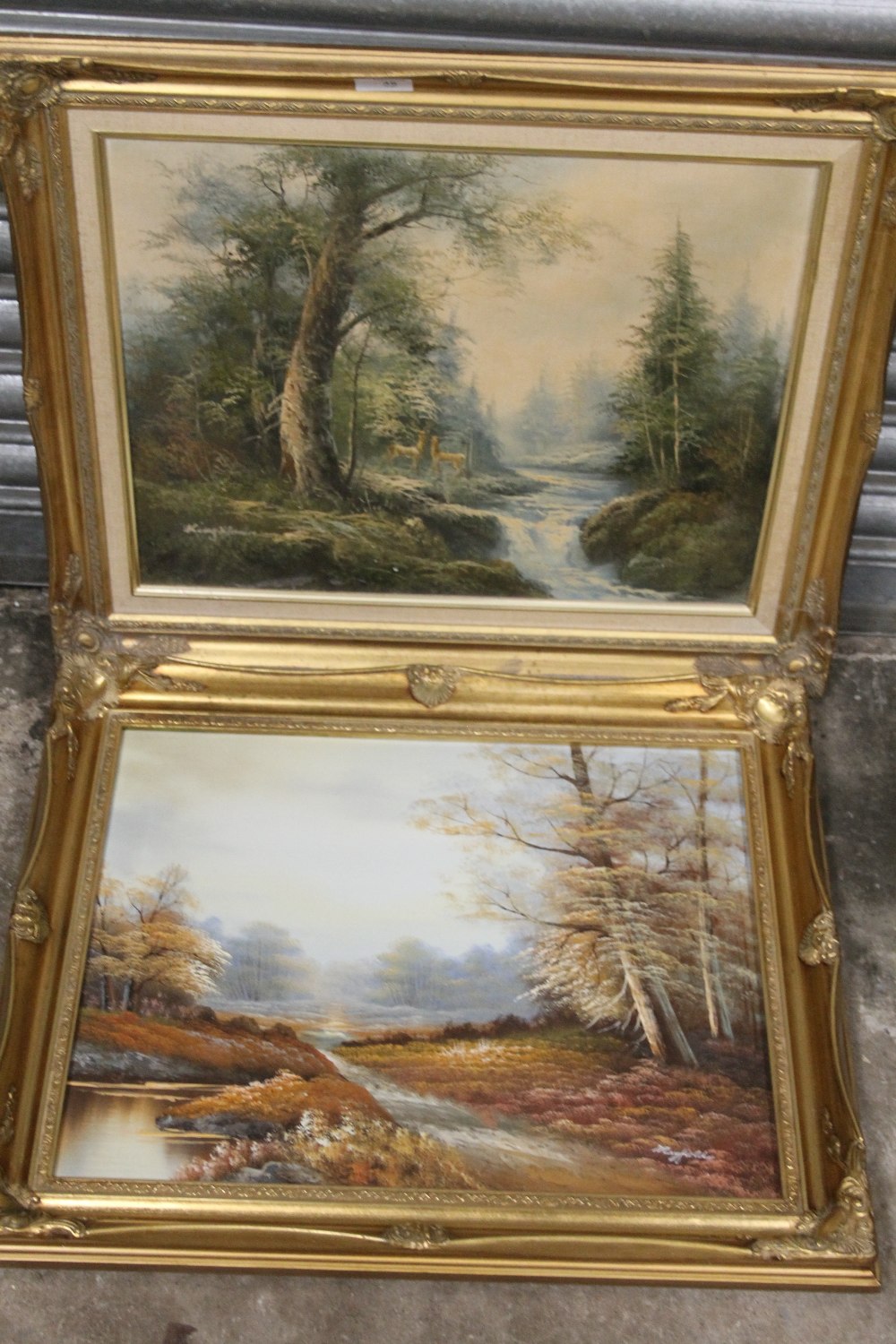 TWO GILT FRAMED OIL ON CANVASES DEPICTING LANDSCAPES ONE WITH DEER, BOTH INDISTINCTLY SIGNED