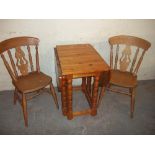 A SOLID PINE DROPLEAF KITCHEN DINING TABLE AND TWO BEECH CHAIRS