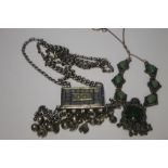 AN OMANI WHITE METAL PRAYER HOLDER AND A GREEN STONE NECKLACE