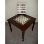 A FOLD AWAY CHESS TABLE WITH ONYX MARBLE INSERTED CHESS BOARD AND A BOXED SET OF ONYX MARBLE CHESS