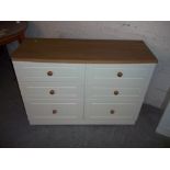 A MODERN CREAM AND OAK FINISH SIX DRAWER CHEST OF DRAWERS