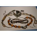 AN EASTERN NECKLACE WITH AMBER COLOURED BEADS TOGETHER WITH A SMALL QUANTITY OF OTHER NECKLACES