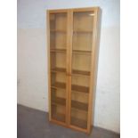 A LIGHT OAK FINISH GLAZED DISPLAY BOOKCASE