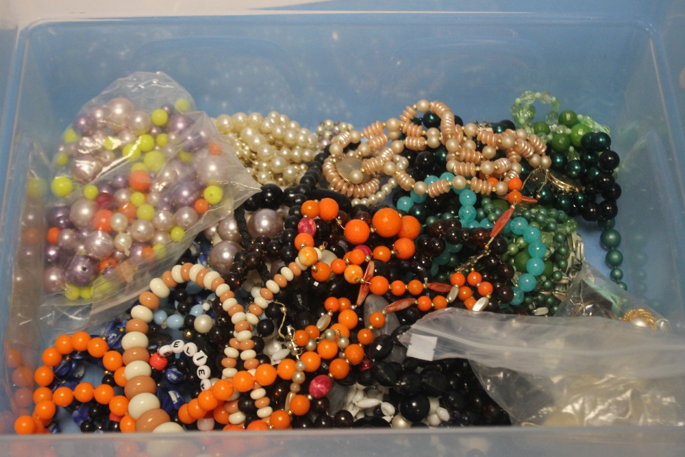 A TUB OF OF ASSORTED COSTUME NECKLACES AND A BAG OF BEADS ETC.