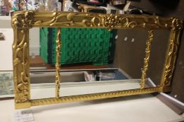 A LARGE GILT FRAMED MIRROR 56 CM X 28 CM