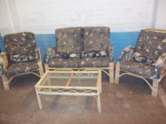 A FOUR PIECE BAMBOO CANE CONSERVATORY SUITE, TWO SEATER SOFA, TABLE AND TWO CHAIRS A/F