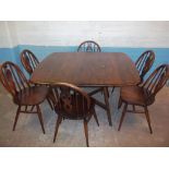 AN ERCOL DROPLEAF DINING TABLE WITH SIX CHAIRS