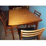 A RETRO TEAK EXTENDING DINING TABLE AND FOUR CHAIRS