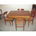 A TEAK EXTENDING DINING TABLE AND FOUR CHAIRS