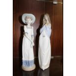 TWO LARGE NAO FIGURES OF A GIRL HOLDING FLOWERS AND A LADY IN A BONNET