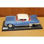 A TIN PLATE MODEL OF A CADILLAC EL DORADO SEVILLE ON STAND