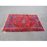 A LARGE VINTAGE WOOLLEN RUG, MAINLY RED GROUND 210 X 128 cm