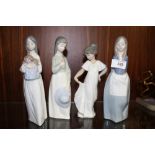FOUR NAO FIGURES OF YOUNG GIRLS, ONE HOLDING A DOLL