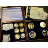 TWO CASES OF GOLD PLATED COMMEMORATIVE COINS TO INCLUDE ENAMELLED EXAMPLES