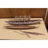 A LARGE OCEANIC MODEL CANOE WITH FOUR PADDLES, TOGETHER WITH A SMALLER POLYNESIAN EXAMPLE WITH A