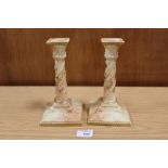 A PAIR OF ROYAL WORCESTER BLUSH IVORY CANDLESTICKS, decorated with hand painted floral and raised