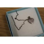 A STERLING SILVER HEART SHAPED LOCKET ON CHAIN