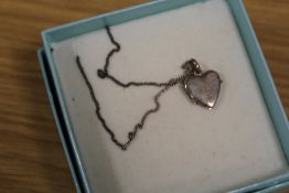 A STERLING SILVER HEART SHAPED LOCKET ON CHAIN