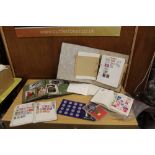 A VINTAGE POSTCARD ALBUM TOGETHER WITH THREE STAMP ALBUMS, COLLECTABLE TOKENS ETC.