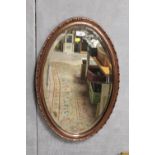 A MODERN BEVEL EDGED OVAL WALL MIRROR IN COPPER EFFECT FRAME, SIZE 74 CM BY 45 CM