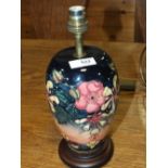 A MOORCROFT 'HONEYSUCKLE' PATTERN TABLE LAMP, with typical tube lined decoration, raised on a