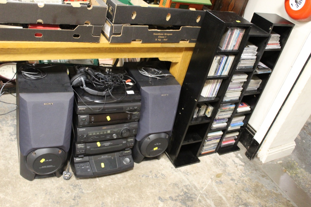 A SONY STACKING STEREO SYSTEM AND SPEAKERS TOGETHER WITH THREE CD RACKS AND CONTENTS