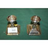 A PAIR OF SMALL HALLMARKED SILVER FILLED CANDLESTICKS HEIGHT - 7CM