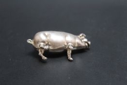 A NOVELTY WHITE METAL PIN CUSHION IN THE FORM OF A PIG, W 5 cm