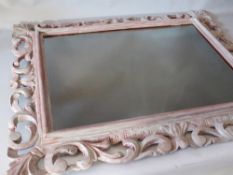 AN 18TH CENTURY CARVED LIMEWOOD FLORENTINE STYLE PICTURE FRAME, later painted and with mirror glass,