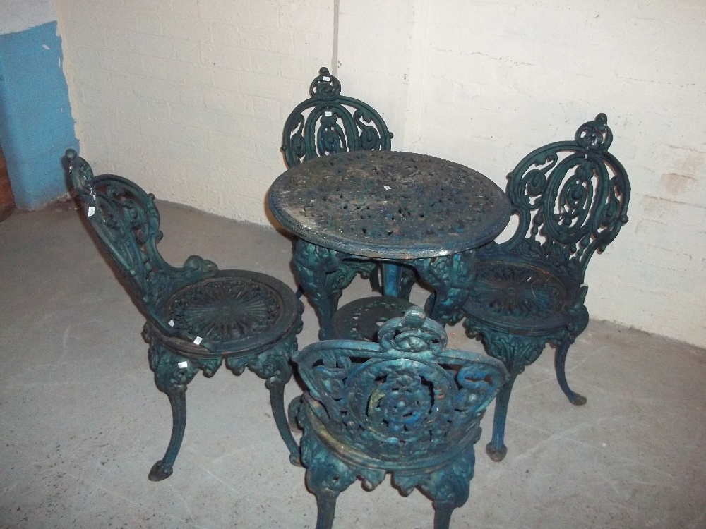 A CAST IRON BRITTAVIA DESIGN GARDEN TABLE AND FOUR MATCHING CHAIRS