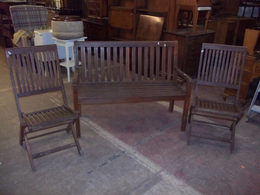 A WOODEN GARDEN BENCH AND TWO FOLDING CHAIRS