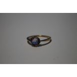 A LADIES YELLOW METAL DRESS RING SET WITH PURPLE STONE