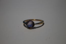 A LADIES YELLOW METAL DRESS RING SET WITH PURPLE STONE