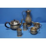 AN INDIAN WHITE METAL THREE PIECE TEA SET, A WATER EWER, TWO BEAKERS AND A MATCHING SPOON. ALL