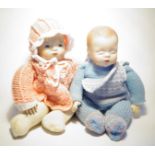 2 Babypuppen mit Porzellanköpfen, ungemarkt, weicher Körper mit Massehänden, H. je 35 cm