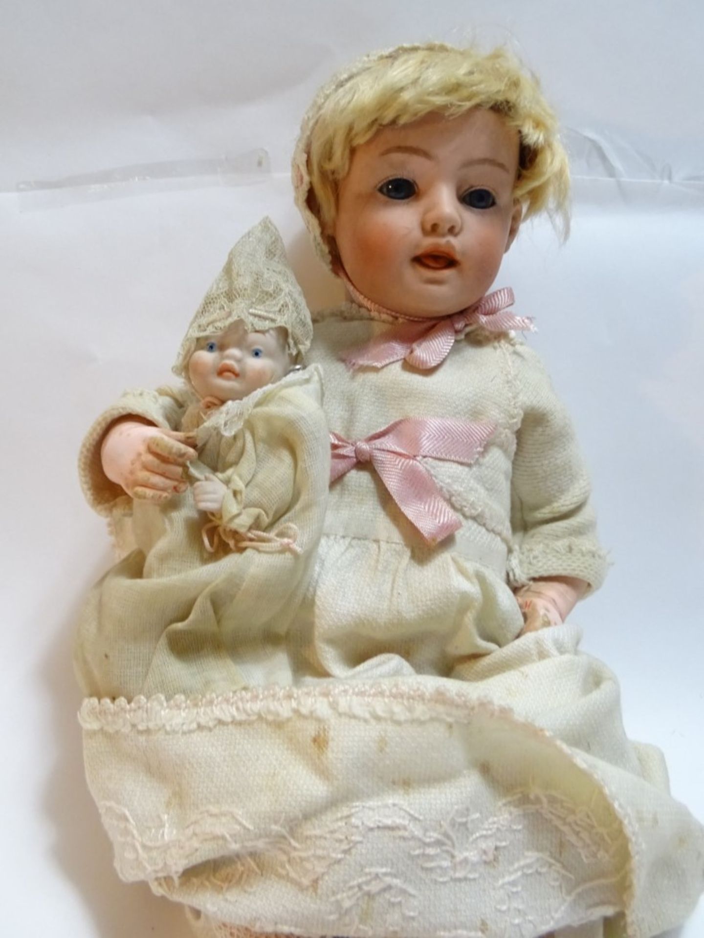 Alte Puppe mit Porzellankopf und kleiner Porzellanpuppe, bei dieser Teile am Halsausschnitt