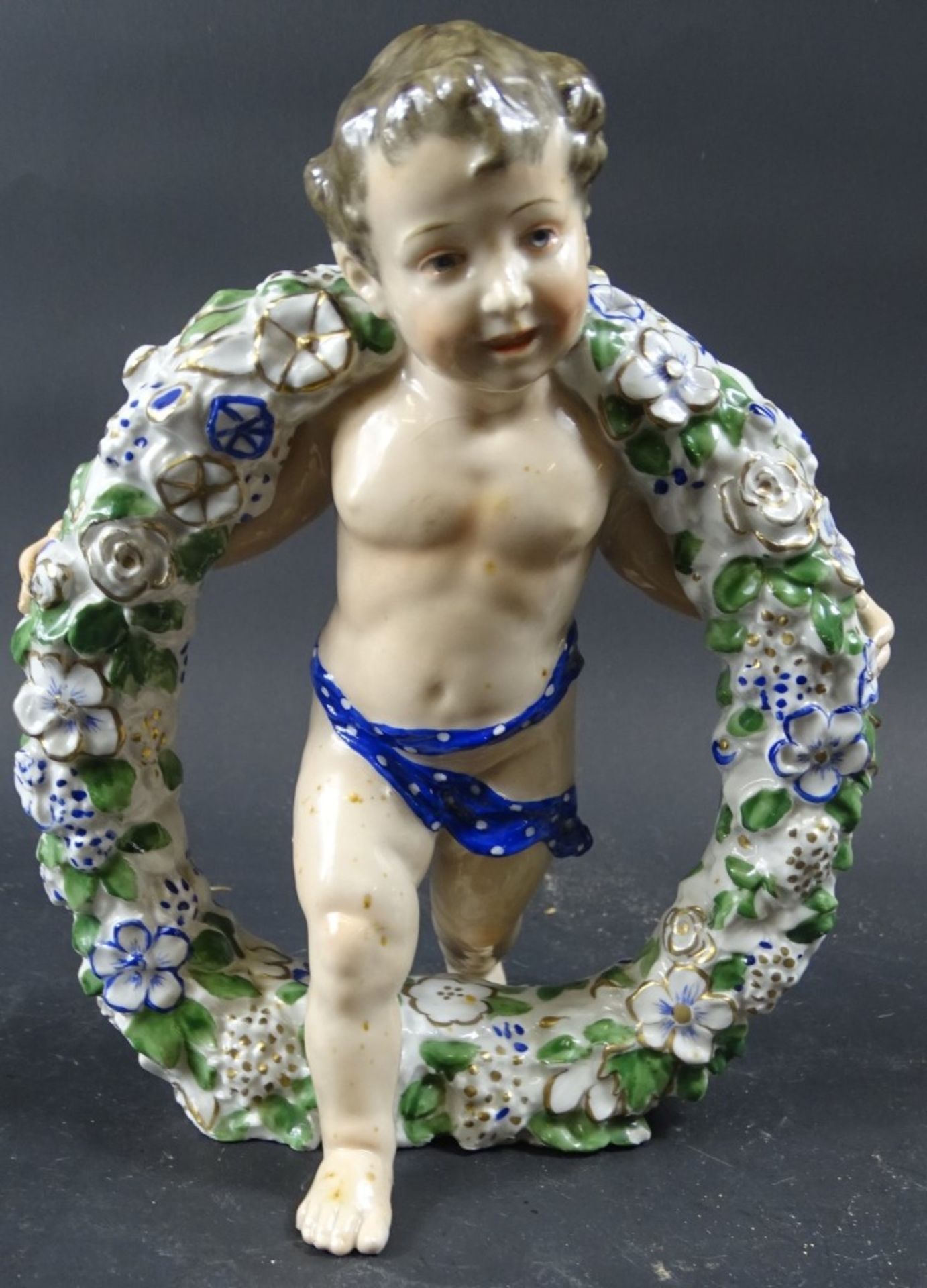 Porzellanfigur, Knabe mit Blumenkranz, KVE-Marke, H. ca. 20,5 cm, Körper weist Flecken auf
