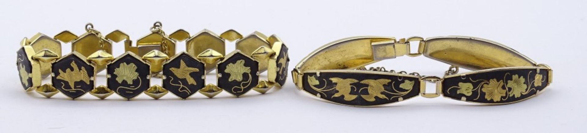 zwei goldfarbene Armbänder mit Tier und Blumenmotiven