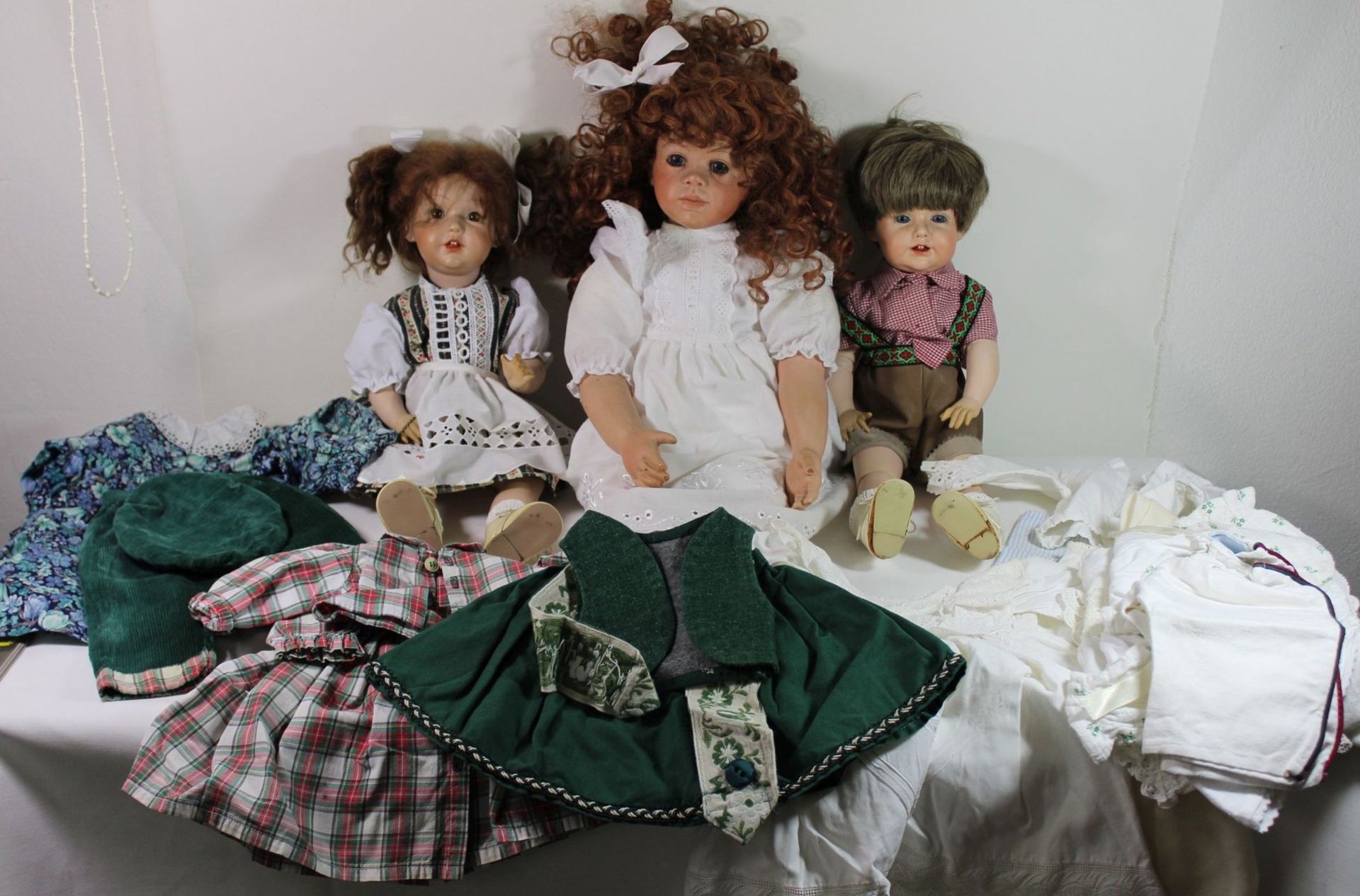 3x div. Künstlerpuppen sowie div. Kleidung, Puppen gemarkt und datiert, 1988/91.