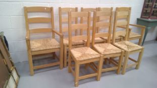 Eight light oak ladder back chairs with rush seats