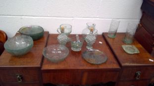 A collection of green plates and bowls, along with similar style glassware.