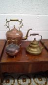 Large late 19th-century copper and brass kettle, a smaller copper kettle, and a brass kettle.