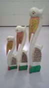 Three graduating wood-carved and painted storks, the largest 101cm.