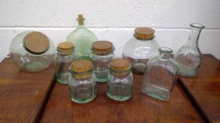 Glass storage jars most with cork stoppers.