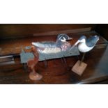 Tin coat hooks modeled as a duck, wood carved stork and a painted wood model of a wading bird.